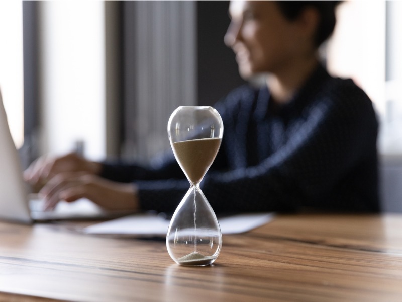 Mesure du temps avec un sablier, femme d'affaires indienne travaillant.