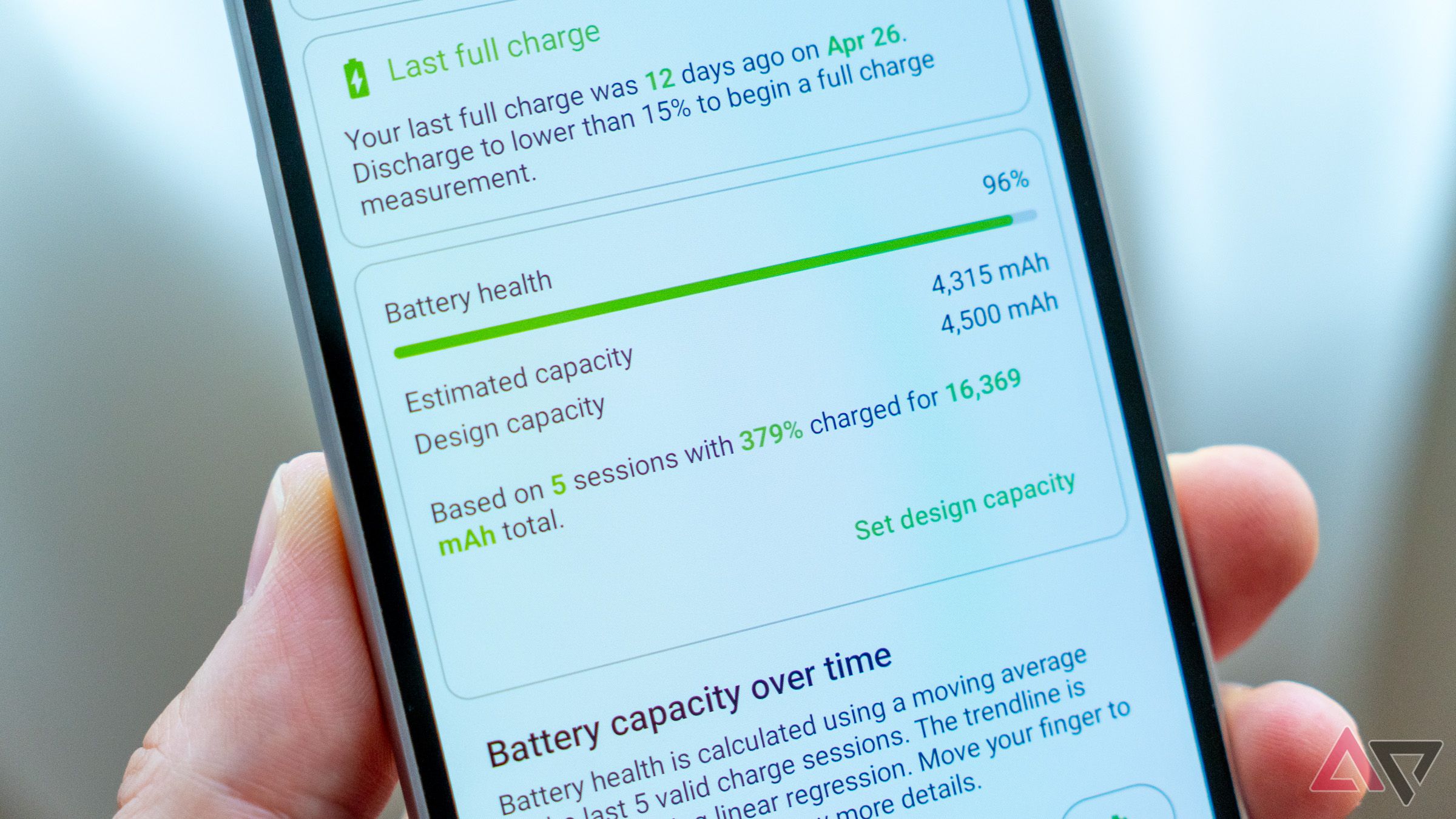 Un téléphone dans une main affichant l'état de santé de la batterie dans l'application AccuBattery