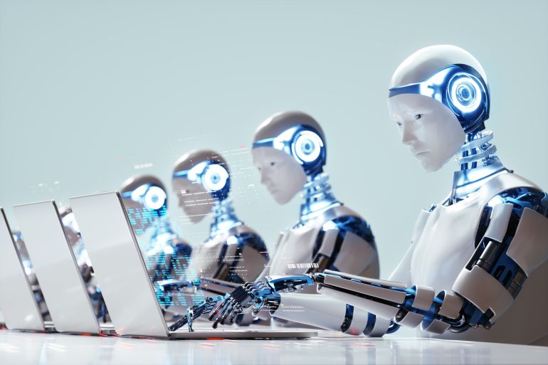 Robots travaillant sur des ordinateurs portables, illustrant l'automatisation et l'IA