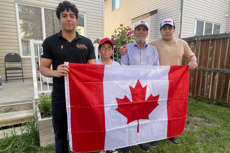 Abdelaziz Alwadia avec ses enfants nés au Canada tenant le drapeau canadien