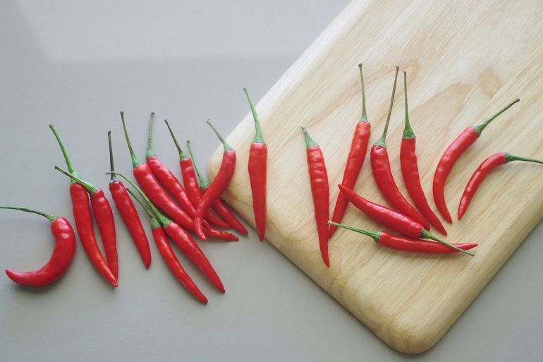 Collection vibrante de piments rouges frais sur une planche en bois