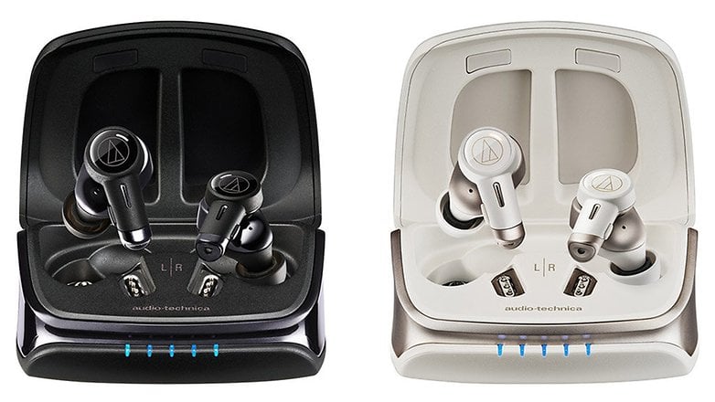 Deux paires d'écouteurs sans fil Audio-Technica noirs et blancs dans leurs étuis de chargement.