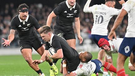 Beauden Barrett plaqué lors de Nouvelle-Zélande-France à Dunedin, le 5 juillet 2025. (SANKA VIDANAGAMA / AFP)