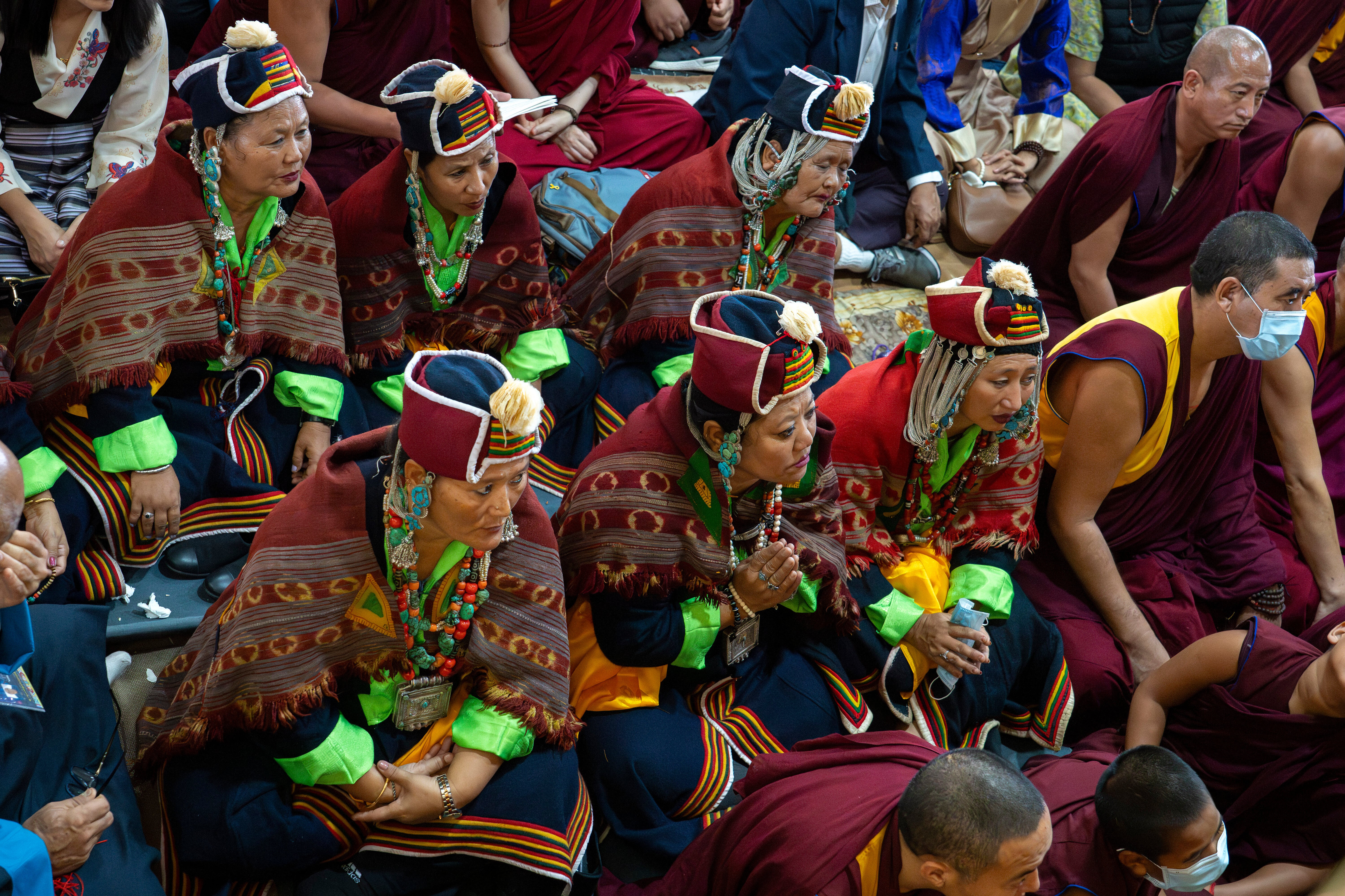 Des dévots regardent le Dalai Lama à la télévision lors de l'événement.