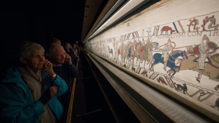 Des visiteurs admirent la tapisserie de Bayeux, exposée dans cette ville du Calvados le 13 septembre 2019