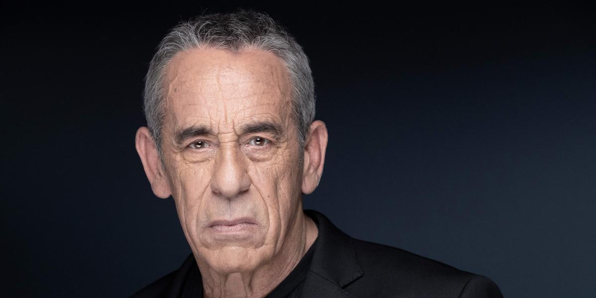 Thierry Ardisson lors d'une interview, pâle silhouette à l'image classique du journaliste