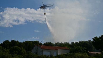 Un hélicoptère effectue un largage contre les flammes près de Martigues (Bouches-du-Rhône), le 18 juillet 2025.