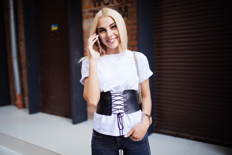 Jeune femme utilisant son téléphone portable dans la rue