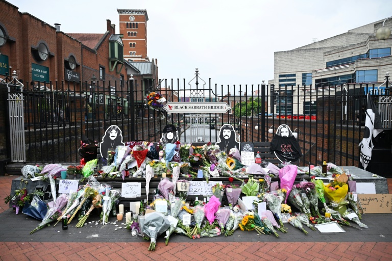 Fans rassemblés devant une statue ou un lieu emblématique d'Ozzy Osbourne à Birmingham