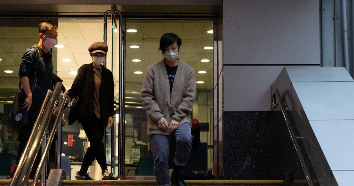Policiers hongkongais avec affiches de recherche d'activistes