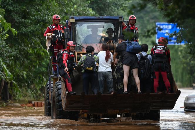 Des secouristes évacuent des résidents du village de Taishitun, dans le district de Miyun, en périphérie de Pékin, le 28 juillet 2025.