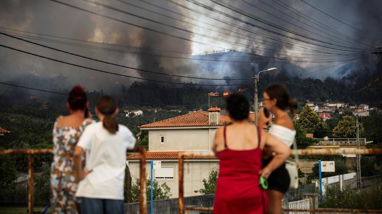 Des habitants surveillent un feu sur les collines entourant Gondomar, dans le nord du Portugal, le 29 juillet 2025