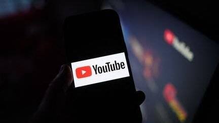 Le logo de Youtube sur un smartphone et une télévision, à Dresde, en Allemagne, le 3 février 2025. (ROBERT MICHAEL / DPA / AFP)