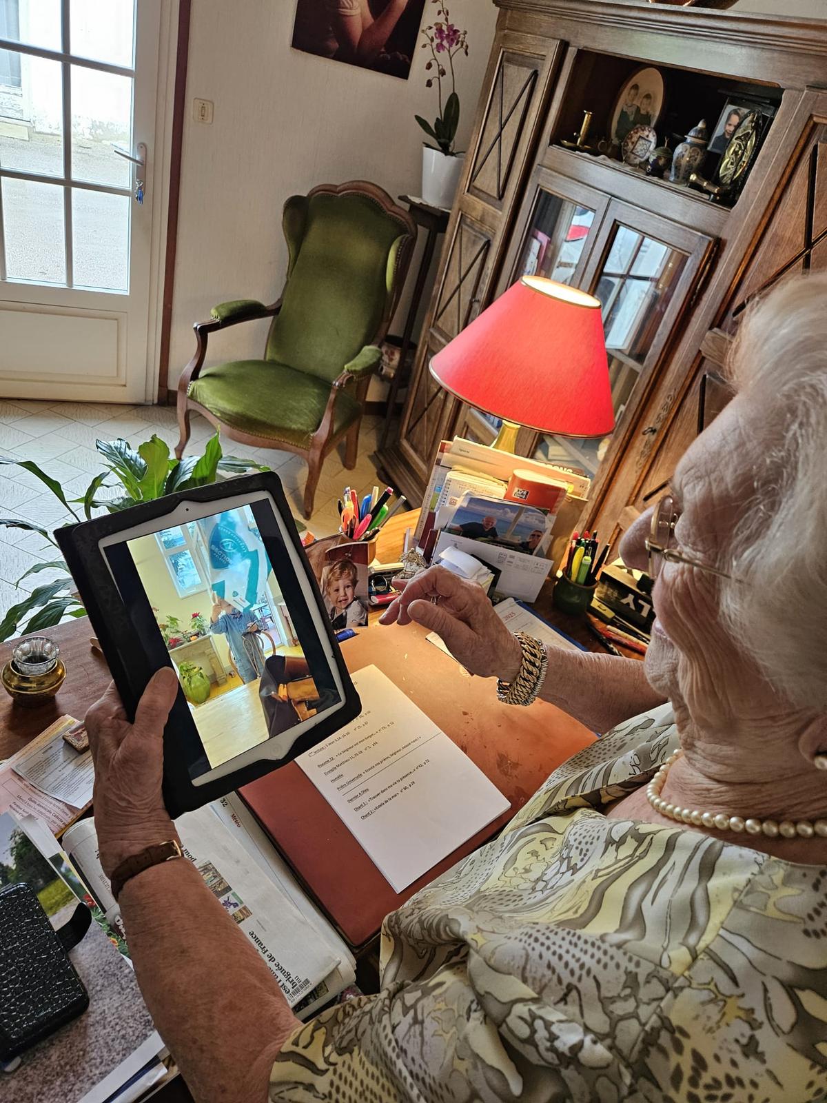 Marie-Antoinette Pontneau, dans son bureau, regarde la vidéo de son arrière-petit-fils agitant un drapeau de la Section paloise.