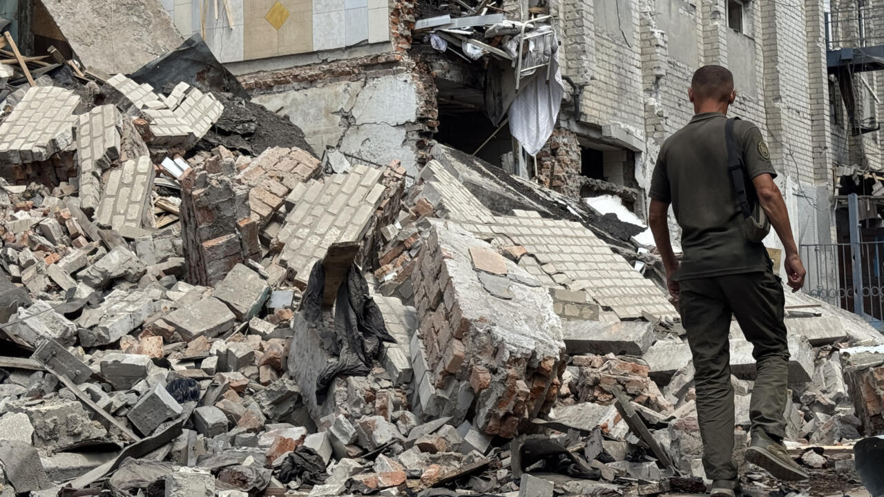 Un agent des forces de l'ordre ukrainiennes devant un bâtiment détruit de la colonie correctionnelle de Bilenkivska suite à une attaque aérienne.