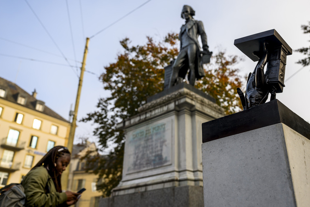 Femme regardant la statue de David de Pury à Neuchâtel.