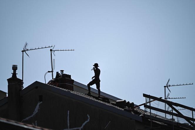 Un couvreur sur un toit, alors que les températures dépassaient les 35 °C, à Lyon, le 30 juin 2025.
