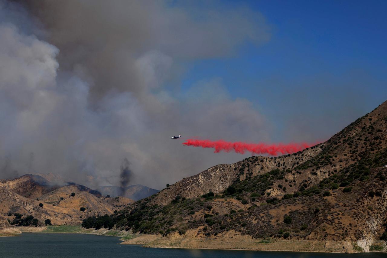 Un avion largue du produit ignifuge sur une colline lors du Canyon Fire, à Piru (Californie), le 7 août 2025.