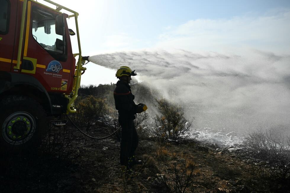 Des pompiers éteignent des cendres chaudes à côté d'Albas, dans le massif des Corbières, le 9 août 2025.