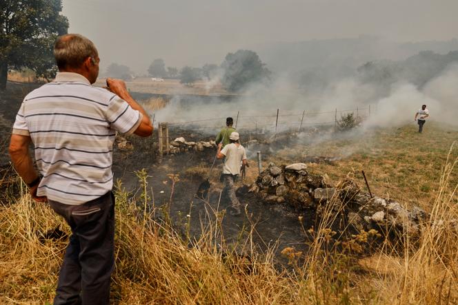 Habitants tentant d’éteindre un feu à Pareisas, dans le nord-ouest de l’Espagne, le 13 août 2025