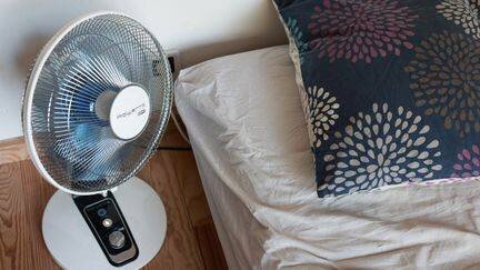 Ventilateur près d'un lit pendant la canicule