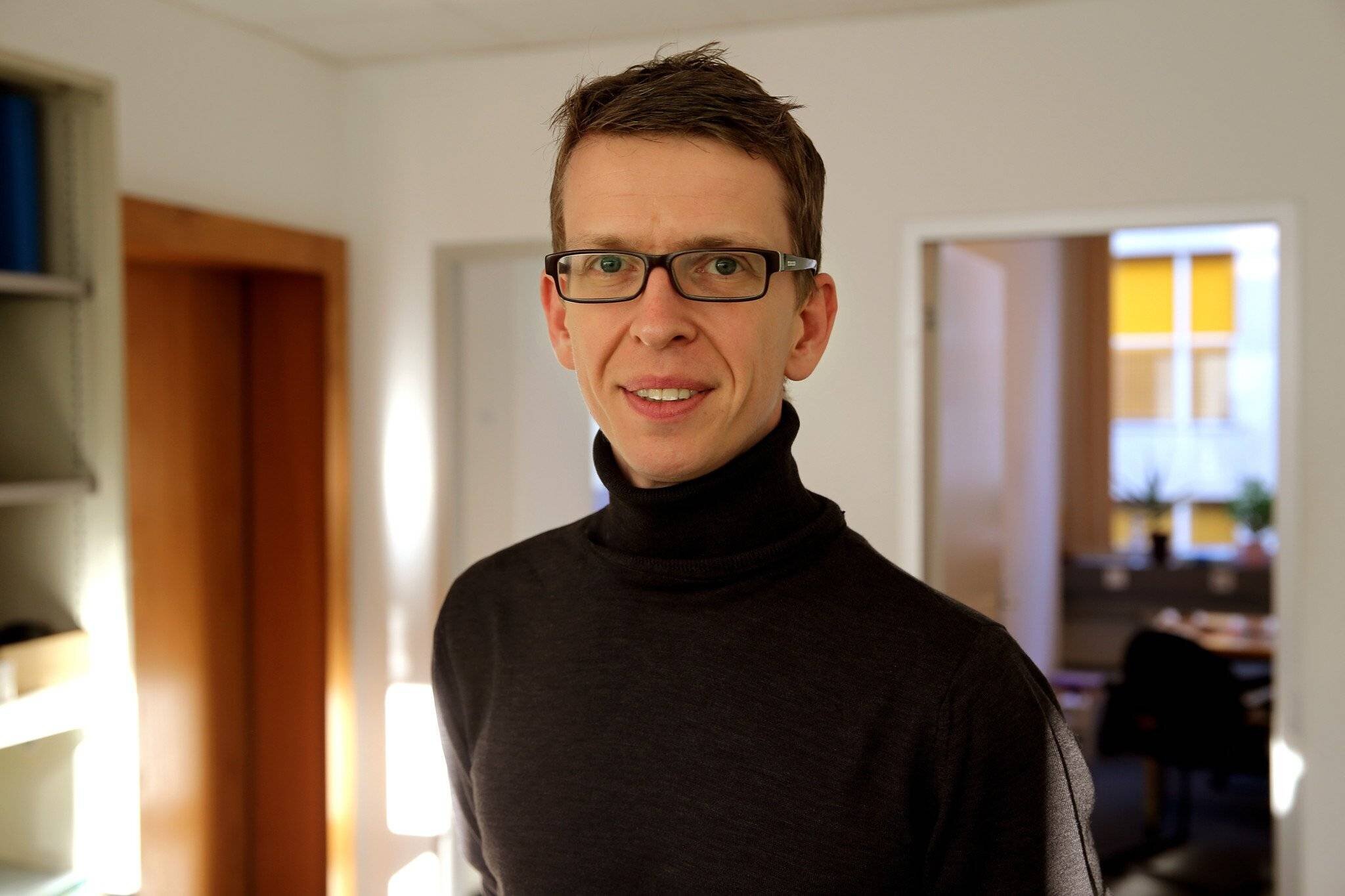 Homme portant lunettes dans un bureau à Genève