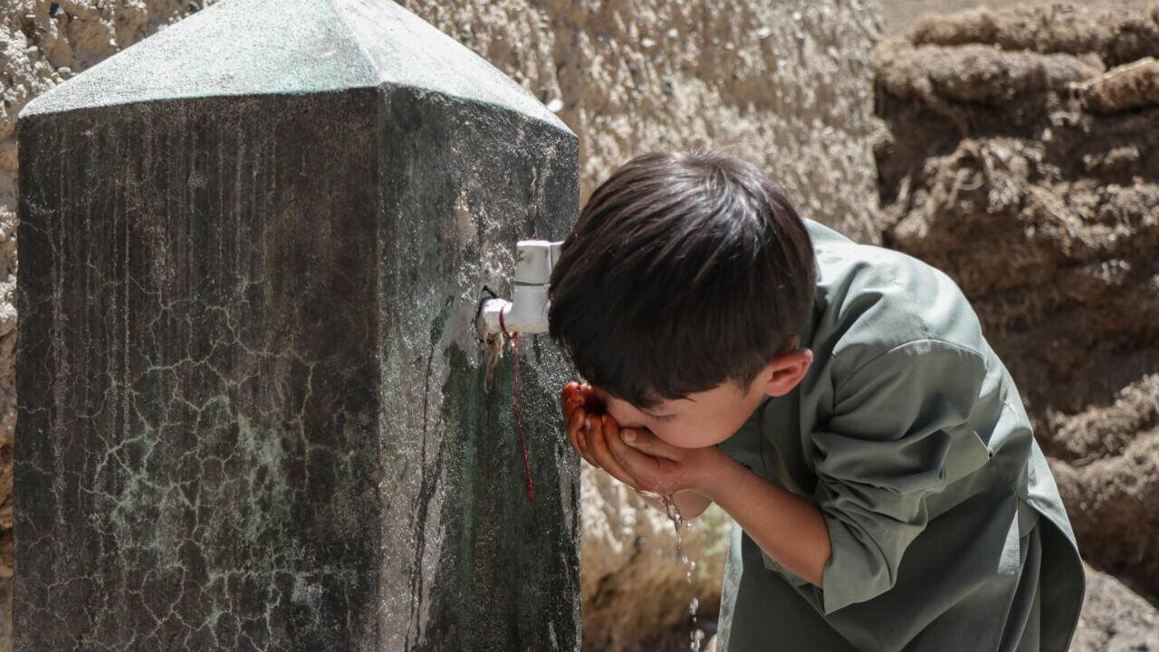 Enfant buvant à une fontaine en Afghanistan