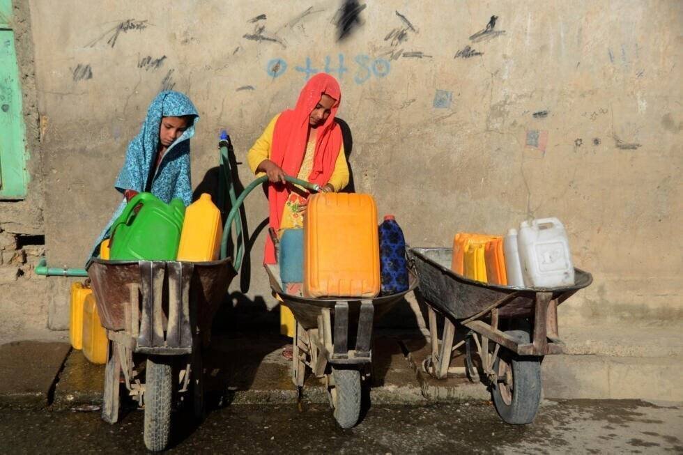 Jeunes filles remplissant jerrycans à Kandahar