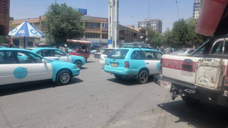 Circulation et véhicules de police dans une rue de Kaboul