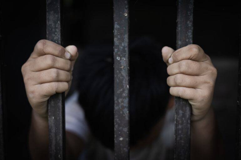 Enfant derrière une grille, symbolisant la protection contre la violence et la traite