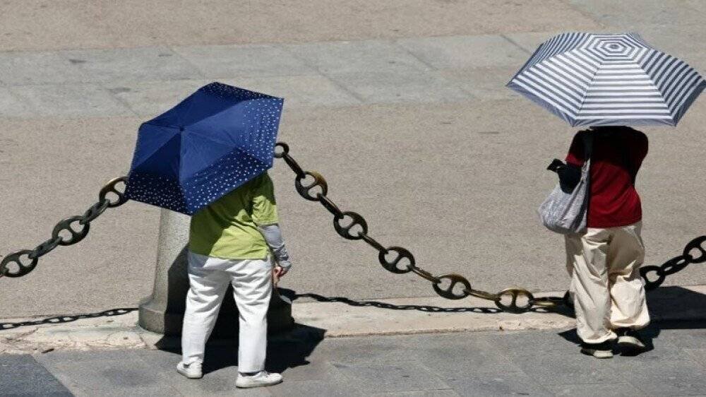 Des personnes se protégeant de la chaleur à Madrid lors d'une vague de chaleur