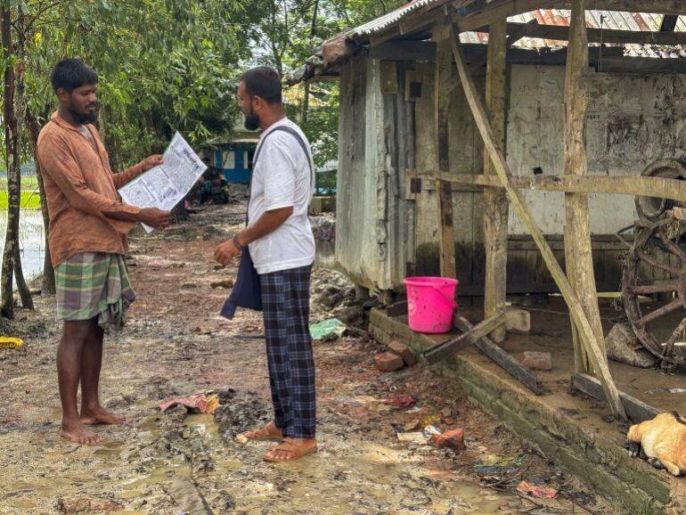 Hasan livre un journal à un villageois
