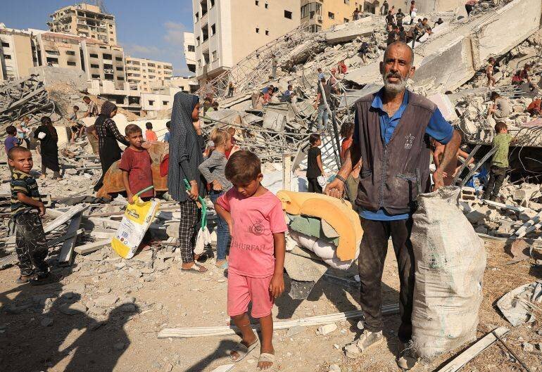 Palestiniens inspectent les décombres d'un immeuble frappé par des frappes aériennes à Gaza