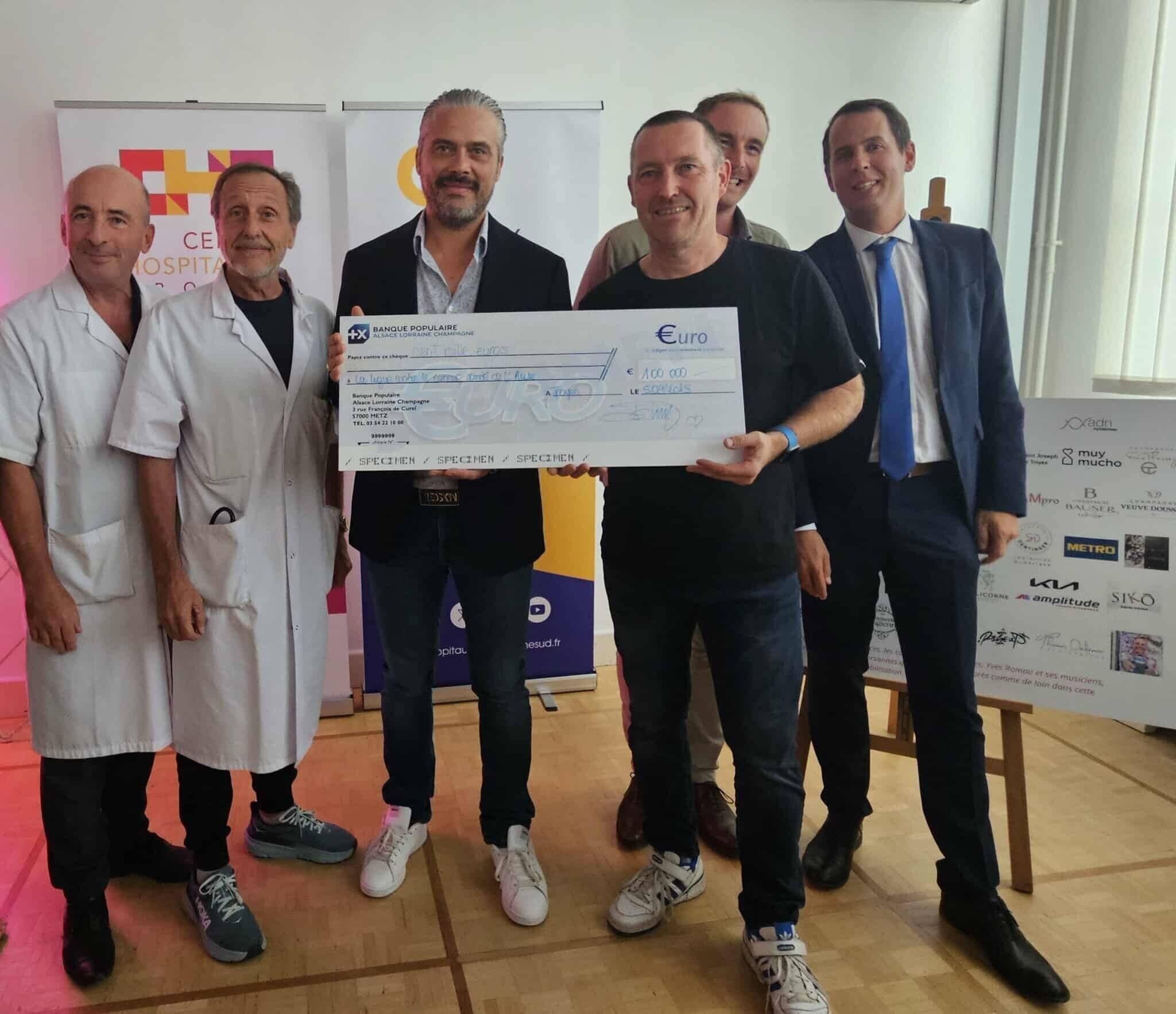 Alexandre Melin, président des Vitrines de Troyes (4e à droite) remet ce 5 septembre un chèque de 100 000 € à Xavier Leseur, président de la Ligue contre le cancer de l'Aube