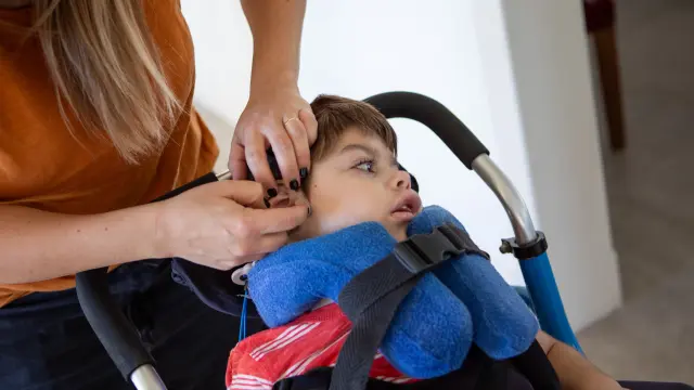 Une mère s'occupe de son enfant handicapé