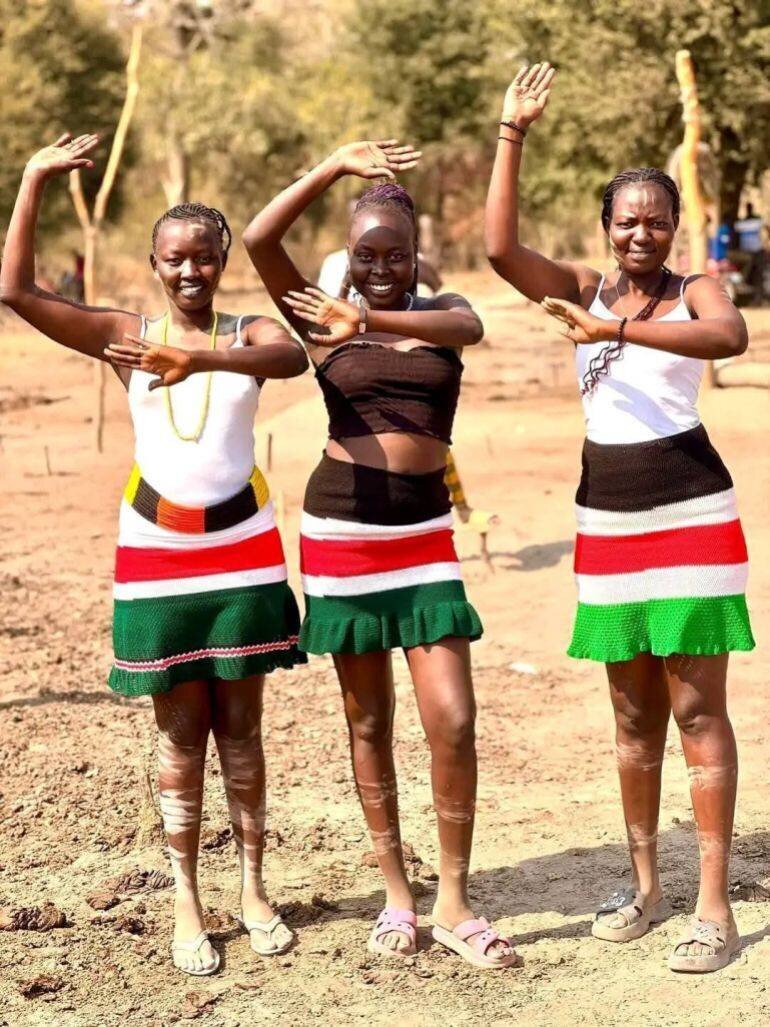 Jeunes filles Dinka mimant les cornes de bovins lors d'une danse