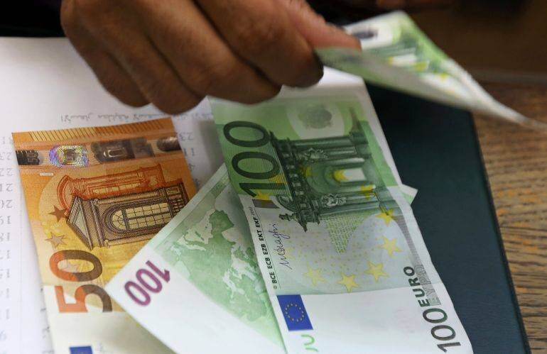 Un employé compte des billets en euros dans un bureau de change au Caire