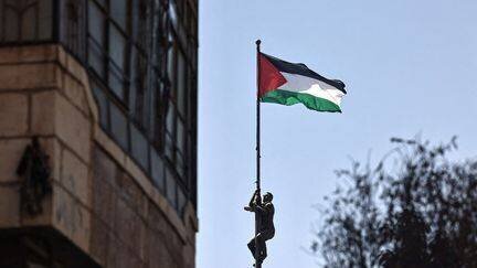 Homme hisse drapeau palestinien à Ramallah