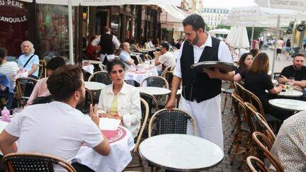 Serveur sur la terrasse d'une brasserie parisienne