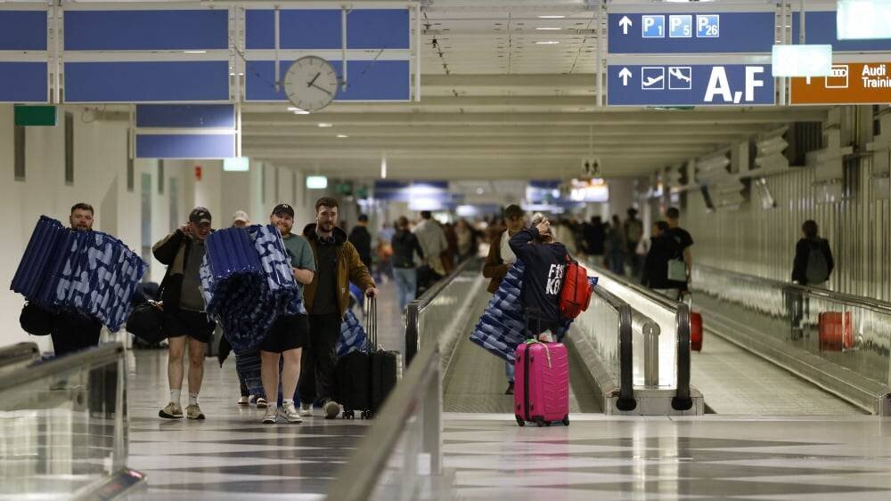 Passagers assis et matelas gonflables à l’aéroport