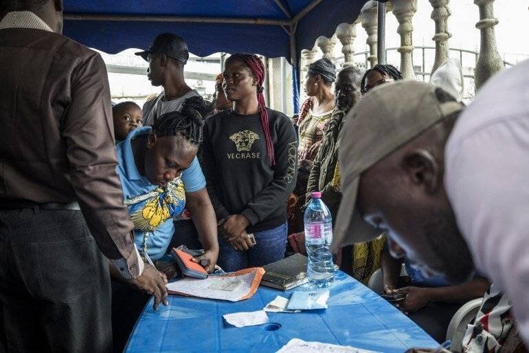 Électeurs camerounais font la queue à Douala pour récupérer leur carte électorale, 8 octobre 2025.