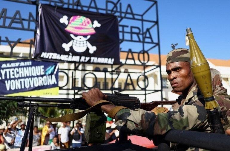 Un militaire observe une banderole lors d'une manifestation