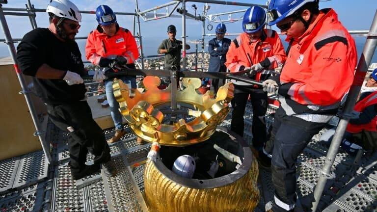 Des ouvriers remettent en place la couronne dorée de la Bonne-Mère