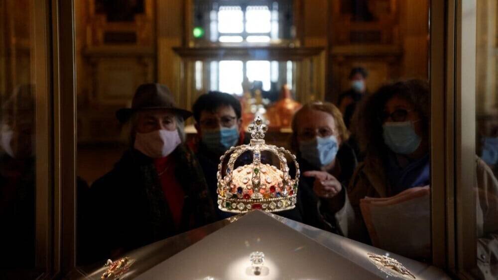 Visiteurs regardant la couronne exposée au Louvre