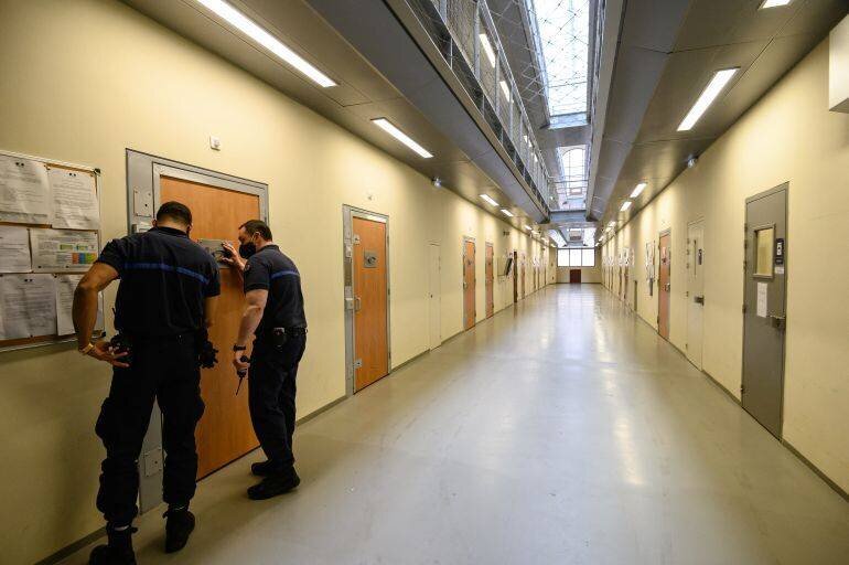 Gardiens fermant une porte dans un couloir de la prison de La Santé, Paris