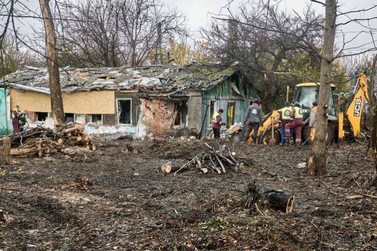 Travailleurs ukrainiens sur le site d'une frappe aérienne russe à Kharkiv