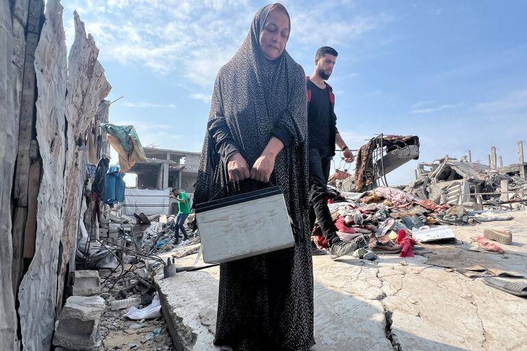 Najat Abu Seif dans sa maison détruite, allant chercher de l'eau à distance
