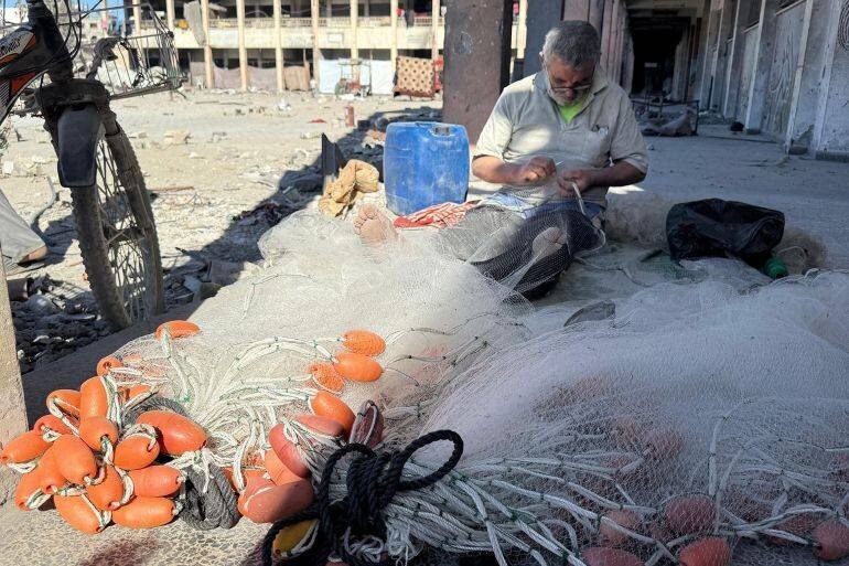 Homme réparant un filet de pêche