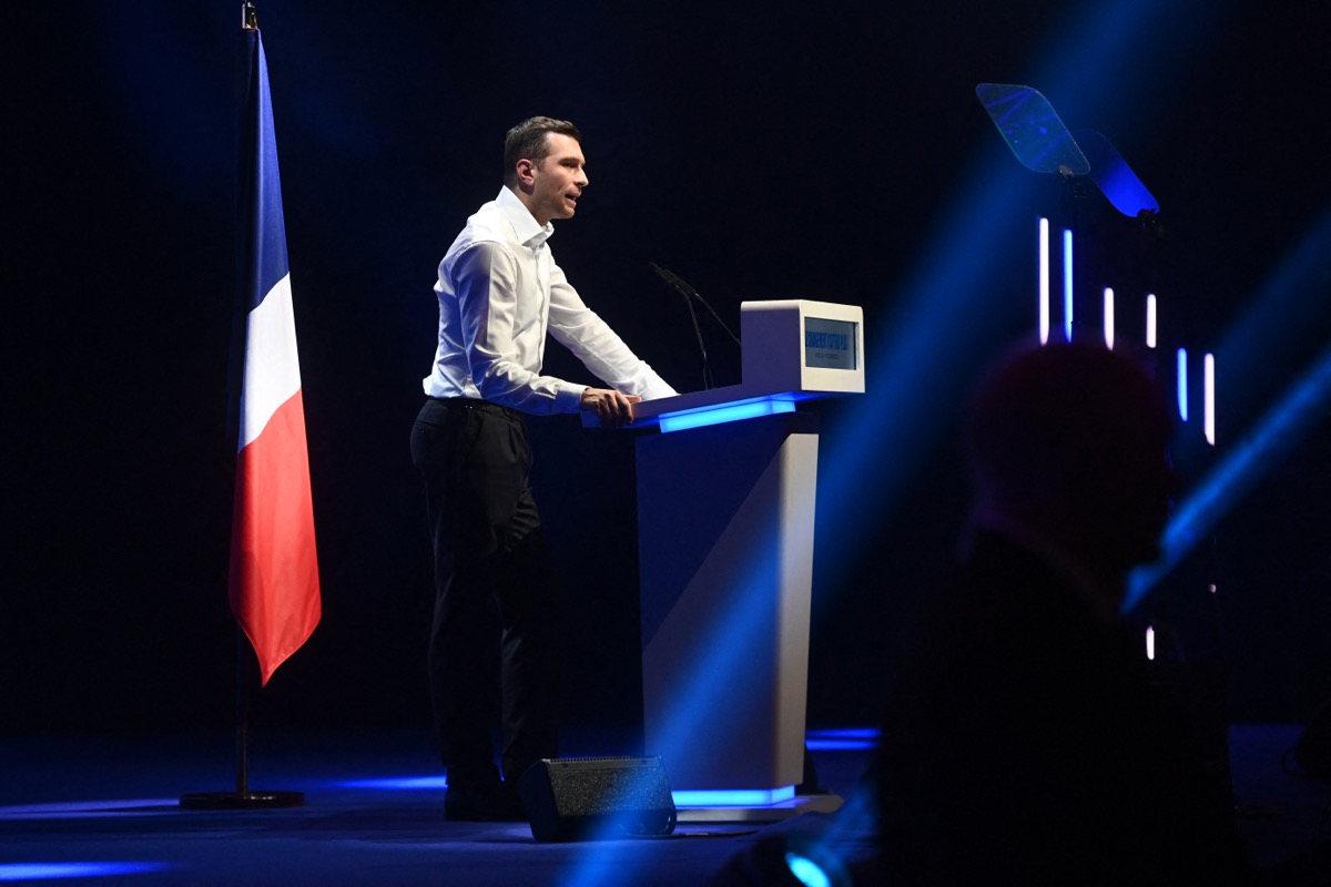 Jordan Bardella au second plan lors d'un meeting