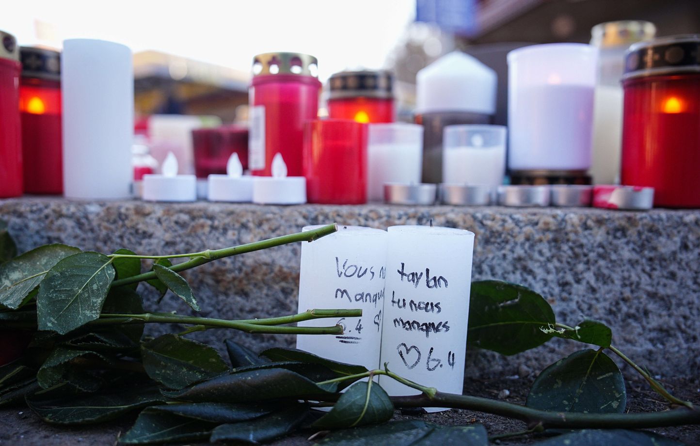 Bougies et fleurs près du bar Le Constellation après l’incendie